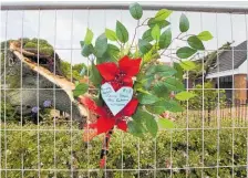  ??  ?? Flowers placed on the fence near the old tree which fell and killed Trish Butterwort­h.