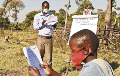  ??  ?? In Narok County, Kenya, as schools remain closed, some children are still able to learn vital literacy skills in an open-air classroom thanks to teachers in the region trained by World Vision Kenya.