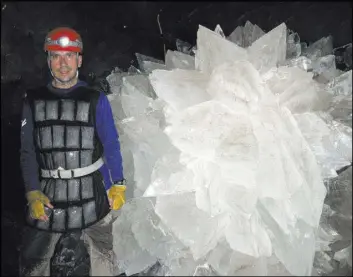  ?? MIKE SPILDE VIA THE ASSOCIATED PRESS ?? In an image provided by Mike Spilde, Mario Corsalini stands near to a gypsum rosette crystal in dormant caves in Naica, Mexico. Scientists have discovered life trapped inside cave crystals that could be 50,000 years old.