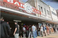  ??  ?? Barbecue lovers such as these lined up at Louie Mueller Barbecue in Taylor hope to be back to favorite restaurant­s soon.