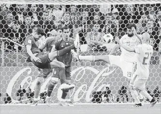  ?? SERGEI GRITS THE ASSOCIATED PRESS ?? Iran’s Milad Mohammadi, left, leaps as he clears the ball from Spain’s Diego Costa during Spain’s 1-0 win at the 2018 World Cup Wednesday.