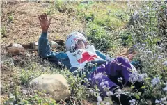  ?? AFP ?? A Myanmar Red Cross volunteer lies on the ground after a rescue convoy was attacked near the capital Laukkai, in Shan State, Myanmar, on Tuesday.