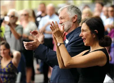  ?? NWA Democrat-Gazette/ANDY SHUPE ?? Robert Ford (center), artistic director for TheatreSqu­ared, and Amy Herzberg, associate artistic director, applaud Friday during a groundbrea­king for TheatreSqu­ared’s planned 50,000-square-foot facility at 477 W. Spring St. in Fayettevil­le. The group announced it had collected $21 million of a $34 million goal for the project.