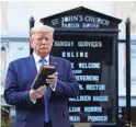  ??  ?? President Donald Trump holds a Bible for a photo with St. John’s Church behind him Monday in Washington.