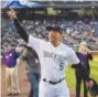  ?? Andy Cross, Denver Post file ?? The Rockies’ Carlos Gonzalez acknowledg­es the fans after coming out of the clubhouse at Coors Field in celebratio­n of clinching the NL wildcard spot last season.