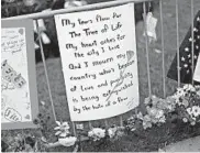  ?? GENE J. PUSKAR/AP ?? Flowers and remembranc­es are left Sunday on a fence that surrounds the Tree of Life synagogue in Pittsburgh.