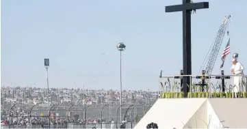  ?? [AP PHOTO] ?? Hundreds of people gathered a few yards away on the U.S. side watch Wednesday as Pope Francis prays near the U.S.-Mexico border fence along the Rio Grande, in Ciudad Juarez, Mexico.