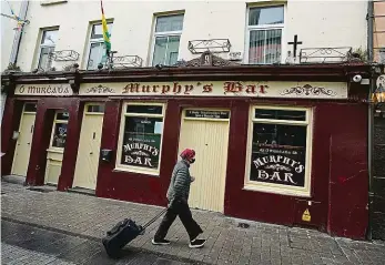  ?? Foto: Reuters ?? Žena prochází kolem zavřené hospody ve městě Galway.