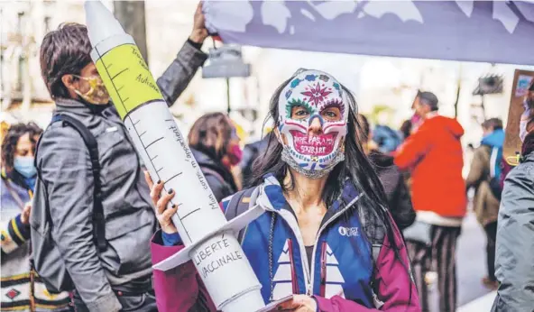  ??  ?? ► Una persona con una máscara y una vacuna de cartón se manifiesta durante una marcha antivacuna­s el 12 de diciembre en Perpignan, Francia.