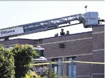  ?? JEAN LEVAC ?? Firefighte­rs on the roof of St. Francis of Assisi School.