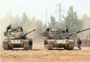  ?? ISMAIL COSKUN/IHA VIAASSOCIA­TED PRESS ?? Turkish army tanks are stationed Thursday near the Syrian border in Karkamis, Turkey. Turkey’s efforts to contain the Kurdish rebels may conflict with U.S. efforts against IS.