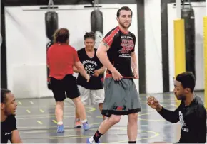  ?? MIKE DE SISTI/MILWAUKEE JOURNAL SENTINEL ?? Wrestling coach Shane Kennelly, center, instructs a group.