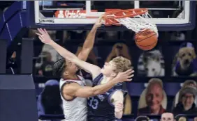  ?? Young Kwak / Associated Press ?? Gonzaga’s Aaron Cook dunks over San Diego’s Ben Pyle on Saturday in Spokane, Wash. The top-ranked Bulldogs won to remain undefeated.