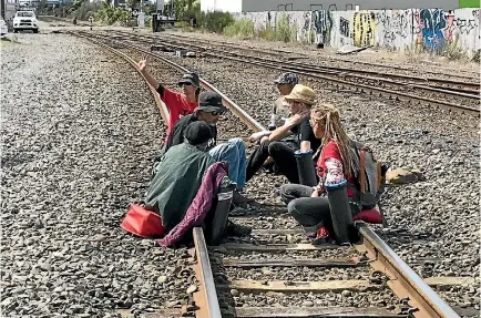  ?? PHOTO: IAIN MCGREGOR/STUFF ?? Six people locked themselves to a train track in Christchur­ch in protest against the re-branded TPPA.