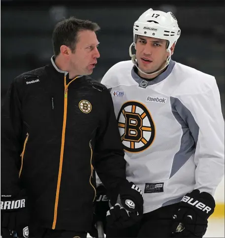  ?? STAFF PHOTO BY MATT STONE ?? Boston Bruins left wing Milan Lucic talks with Assistant Coach Joe Sacco during practice at Ristuccia Arena on Tuesday, October 14, 2014.