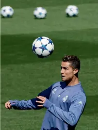  ?? — AFP ?? Real madrid striker Cristiano Ronaldo heads the ball during a training session in madrid on monday.