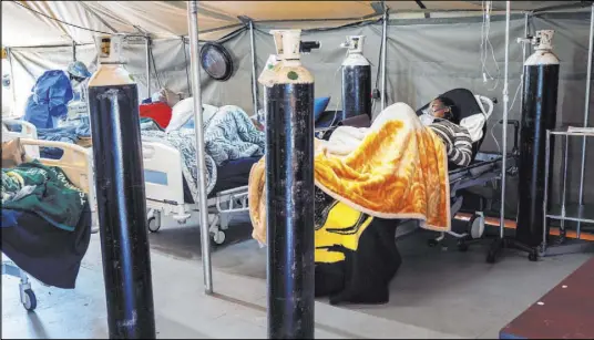  ?? Jerome Delay The Associated Press ?? Coronaviru­s patients are treated with oxygen at the Tshwane District Hospital in Pretoria, South Africa, on Friday. Health Minister Zweli Mkhize this week said South Africa could run out of available hospital beds within the month.