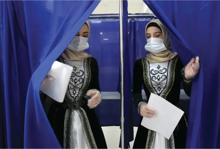  ??  ?? Chechen women wearing Chechen national costumes leave a polling booth at a polling station during the Parliament­ary elections in Grozny, Russia, Sunday, Sept. 19, 2021.