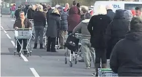  ??  ?? Asda, Tonypandy: An elderly woman heads to the back of the long queue yesterday