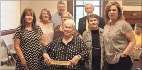  ??  ?? Mike Ragland’s wife, Martha Ragland, holds the nameplate that marked his Cave Spring City Council seat during a ceremony naming the council chambers after the local author and historian who died suddenly in March. Pictured with her (from left) are DDA director Sandra Lindsey, Council members Joyce Mink, Charles Jackson, Nancy Fricks, Tom Lindsey and Nellie McCain and the Raglands’ daughter, Bekki Fox.