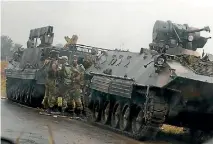  ?? PHOTO: REUTERS ?? Zimbabwean soldiers stand next to armoured personnel carriers on a highway just outside the capital, Harare, yesterday.