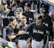  ??  ?? Marlins second baseman Dee Gordon (center) wept openly after he led offff the bottom of the fifirst with his fifirst homer of 2016. He was consoled by second baseman Derek Dietrich (left) and coach Lorenzo Bundy (right).