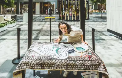  ??  ?? Shan Fazelbhoy working on her art piece on a carpet during the exhibition titled ‘Local Geniuses’ at the City Walk Dubai.