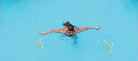  ?? DARRYL DYCK, THE CANADIAN PRESS ?? A lone woman swims in a hotel pool in Kelowna last fall.