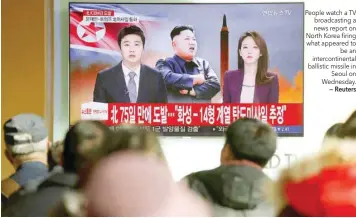  ?? — Reuters ?? People watch a TV broadcasti­ng a news report on North Korea firing what appeared to be an interconti­nental ballistic missile in Seoul on Wednesday.