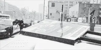  ?? DAVID RITCHIE, SPECIAL TO THE HAMILTON SPECTATOR ?? High winds at Main Street East and Catharine Street South caused a sign promoting the Royal Connaught condominiu­ms to topple. Two men were injured, one seriously.