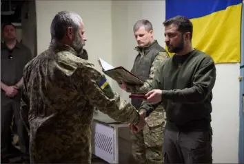  ?? Ukrainian Presidenti­al Press Service via Getty Images ?? Ukrainian President Volodymyr Zelenskyy, right, awards a Ukrainian serviceman Thursday during his visit to the Kherson region in Ukraine.