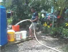  ??  ?? A villager fills up the pails with water from the tanker at Kampung Endap.