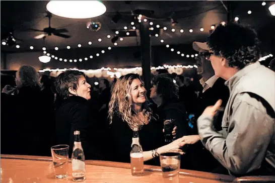  ?? ARMANDO L. SANCHEZ/CHICAGO TRIBUNE PHOTOS ?? From left, Sue Gancer, Diane Zemko, Tom Ottolino, and Dave King talk near the bar at FitzGerald’s during a farewell party on March 4 in Berwyn.