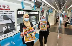  ?? — KAMARUL ARIFFIN/The Star ?? Equal rights for all: Suhakam personnel Norashikin Hamzah and Fatimah showing the #Ride4Right­s contest details.