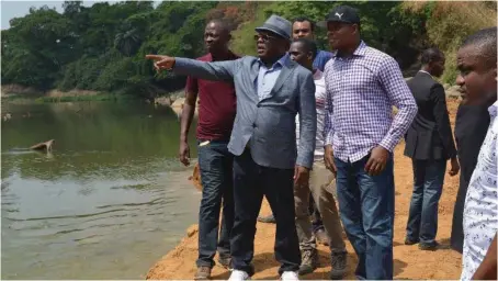  ??  ?? Governor David Umahi of Ebonyi State (pointing); and the Commission­er for Works and Transport, Fidelis Nweze with security operatives inspecting the ongoing constructi­on of Okawu bridge in Onicha Local Government Area… recently