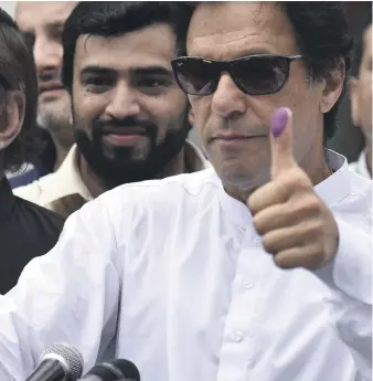  ?? Reuters; EPA ?? Clockwise from top, voters show their identity cards as they queue to cast their ballots in Rawalpindi; a member of the bomb disposal unit collects evidence from the suicide blast site in Quetta; voters in Islamabad receive their papers; thumbs up from...