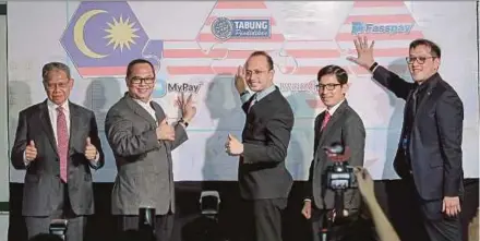  ??  ?? Datuk Seri Mustapa Mohamed (left) giving the thumbs up at the launch of the MyPay e-wallet in Kuala Lumpur yesterday.