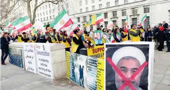  ??  ?? Iranian opposition groups hold a demonstrat­ion in support of protests in Iranian cities outside the prime minister’s residence in London on Thursday. (AN photo)