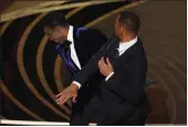  ?? CHRIS PIZZELLO — THE ASSOCIATED PRESS ?? Will Smith, right, hits presenter Chris Rock while the latter was on stage presenting the award for best documentar­y feature at the Oscars on Sunday at the Dolby Theatre in Los Angeles.