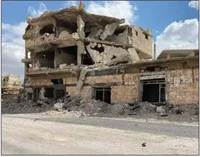  ?? (AP) ?? A building damaged by Syrian government forces following clashes with rebel fighters is seen in the southern city of Daraa, Syria, on Sunday. A Russian-negotiated deal went into effect last week to end a government siege and intense fighting in the city.