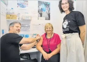  ?? PHOTO: CLINTON LLEWELLYN ?? IMMUNISED: Unichem Pharmacy owner Charles Nairn giving CHB mayor Alex Walker her flu jab last week, as Di Vicary from the Hawke’s Bay District Health Board watches wearing a Beat the Bugs t-shirt.