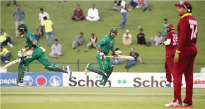  ??  ?? ABU DHABI: Pakistan’s batsmen Babar Azam (L) and Sarfraz Ahmed run between the wickets during the 3rd ODI cricket match between Pakistan and the West Indies at the Sheikh Zayed Cricket Stadium in Abu Dhabi yesterday. — AFP