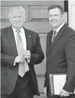  ?? CAROLYN KASTER, AP ?? Kris Kobach, meeting with newly elected President Trump in November, holds a document that has become the focus of an ACLU lawsuit.