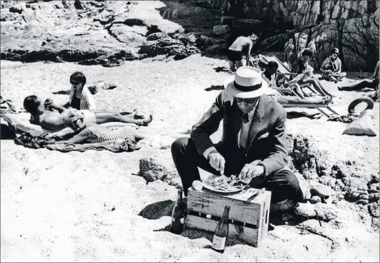  ?? ARXIU FAMILIA ENSESA ?? Josep Ensesa Gubert, con americana y sombrero Panamá, comiendo un plato de pescado en la playa de Sa Conca de S'Agaró, en los años 60
