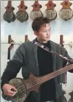  ?? ?? Left: Samdrub Norbu tunes a Tibetan guitar — or dranyan in the Tibetan language — in his shop in Lhasa, Xizang autonomous region, on March 13.