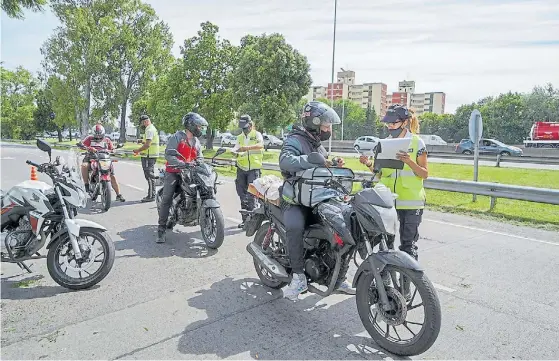  ??  ?? Operativos. Agentes de Tránsito, en algunos casos acompañado­s por efectivos de seguridad, piden documentac­ión a conductore­s de motos.