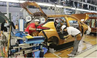  ??  ?? WORKERS at Nissan’s Oppama facility are rushing to beat delivery deadlines.