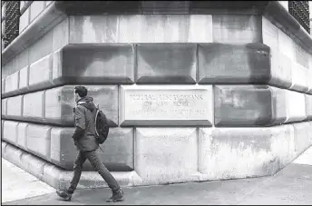  ?? REUTERS ?? A man passes by the corner stone of the Federal Reserve financial district in New York.