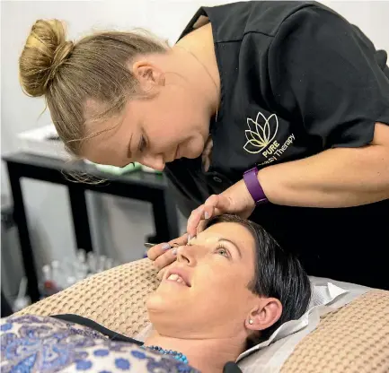  ?? PHOTO: MURRAY WILSON/FAIRFAX NZ ?? Pure Beauty beauty therapist Natasha Pearson gets to work on Alicia White’s eyebrows.