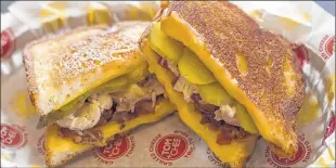  ??  ?? The Flying Pig sandwich is a favorite of Seth Anderson, co-owner of Tom + Chee in Elm Grove. It includes white bread, Gouda, bacon, turkey and pickles, chicken, pepperjack cheese and much more.